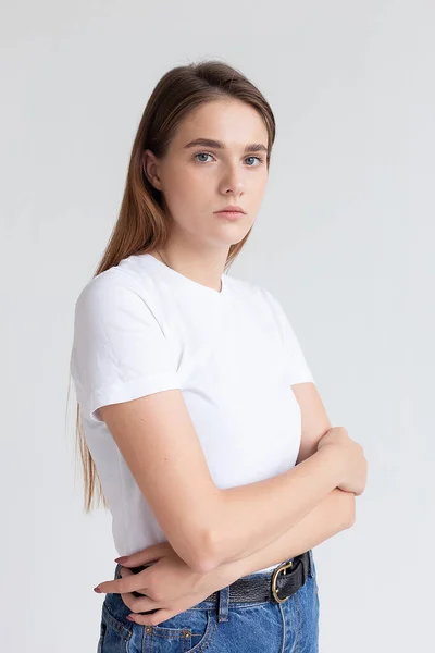 Νεαρή καυκάσια όμορφη κοπέλα με μακριά μαλλιά σε t-shirt, μπλε τζιν στο στούντιο — Φωτογραφία Αρχείου