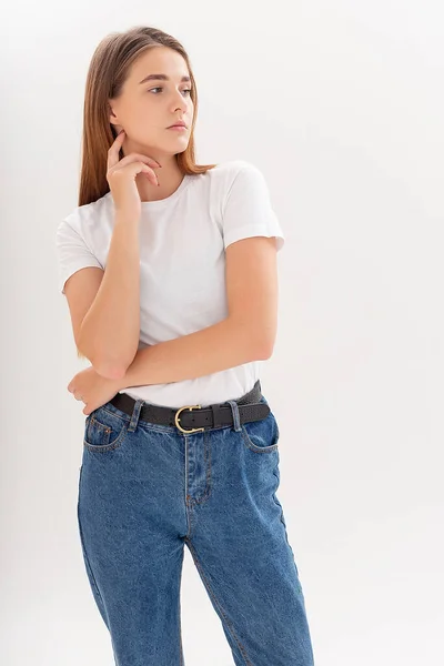 Jeune caucasienne jolie fille aux cheveux longs en t-shirt, jeans bleus au studio — Photo