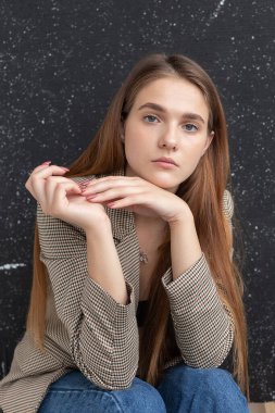 Uzun saçlı, mavi gözlü, takım elbiseli beyaz bir kadın.