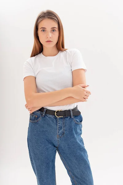 Joven caucásico bonita chica con el pelo largo en camiseta, pantalones vaqueros azules en el estudio —  Fotos de Stock