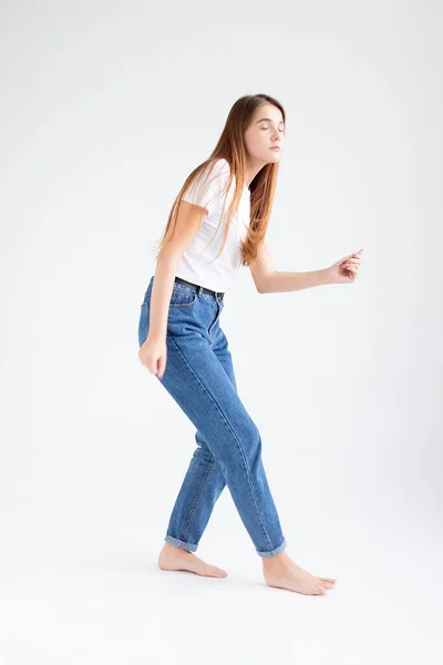 Skinny caucasian pretty female dancing on white studio background with bare feet — Stock Photo, Image