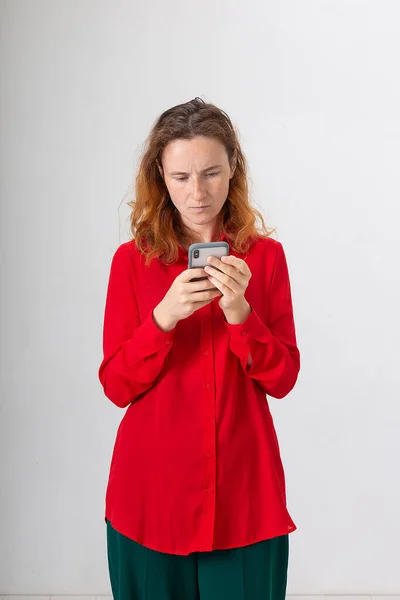 Νεαρή ελκυστική καυκάσια κοκκινομάλλα γυναίκα χρησιμοποιώντας το κινητό τηλέφωνο, κουβέντα στο διαδίκτυο — Φωτογραφία Αρχείου