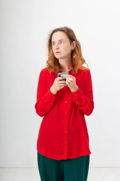 Jovem concentrado caucasiano ruiva mulher usando telefone celular, conversando na web — Fotografia de Stock