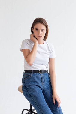 Uzun saçlı, uzun saçlı, stüdyoda kot pantolon giyen beyaz bir kız.