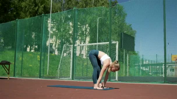 Schlanke Frau, die mit erhobenen Händen in Asana steht. Fitness hübsche Dame arbeitet aus — Stockvideo