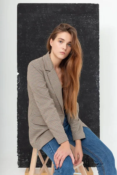 Young attractive caucasian woman with long brown hair in suit jacket at studio — Stock Photo, Image