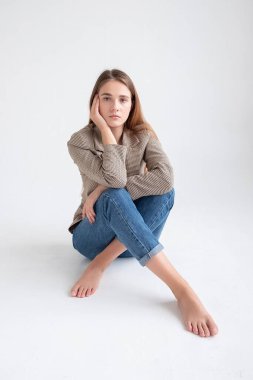 Stüdyoda, uzun kahverengi saçlı, takım elbiseli, beyaz bir kadın vardı.