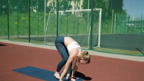 Hoikka nainen seisoo Asana kohotetuin käsin. fitness kaunis nainen treenata — kuvapankkivideo