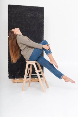 Stüdyoda, uzun kahverengi saçlı, takım elbiseli, beyaz bir kadın vardı.