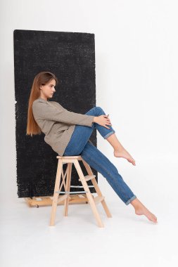 Stüdyoda, uzun kahverengi saçlı, takım elbiseli, beyaz bir kadın vardı.