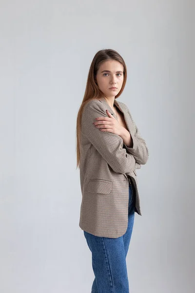 Joven atractiva mujer caucásica con pelo largo marrón en chaqueta de traje en el estudio —  Fotos de Stock