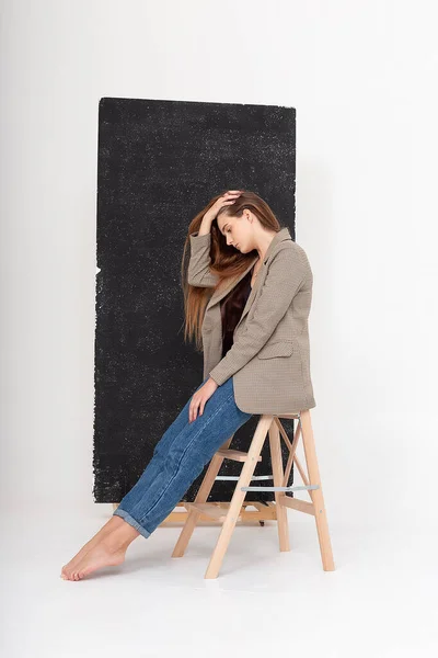 Young attractive caucasian woman with long brown hair in suit jacket at studio — Stock Photo, Image