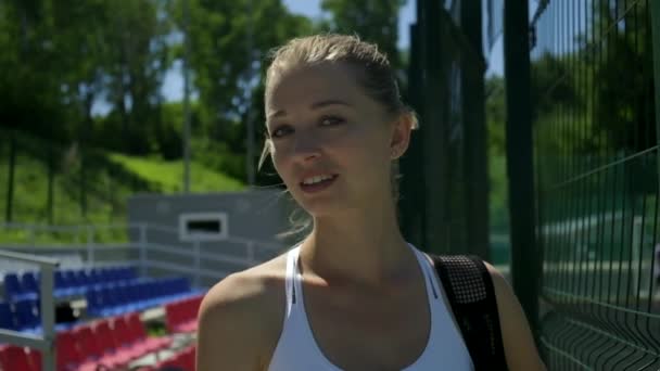 Atractiv caucazian femeie în îmbrăcăminte sport la teren de sport gata pentru a lucra afară — Videoclip de stoc