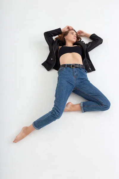 Young caucasian woman with long brown hair in leather jacket on white background — Stock Photo, Image