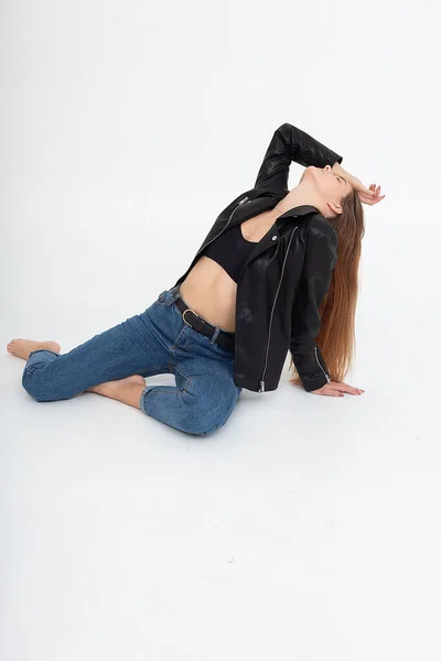 Mujer joven caucásica con pelo largo marrón en chaqueta de cuero sobre fondo blanco — Foto de Stock