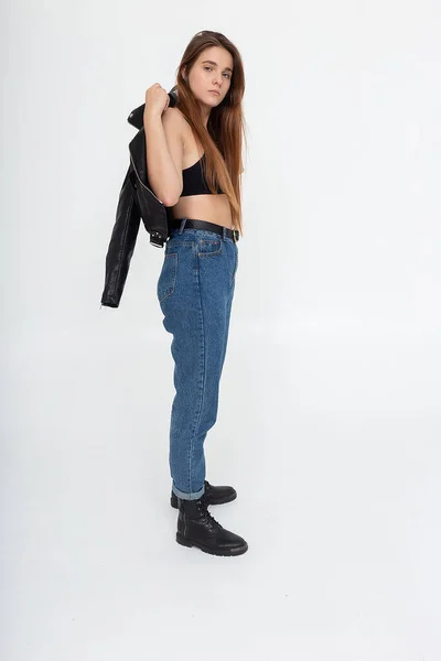 Young caucasian woman with long brown hair in leather jacket on white background — Stock Photo, Image