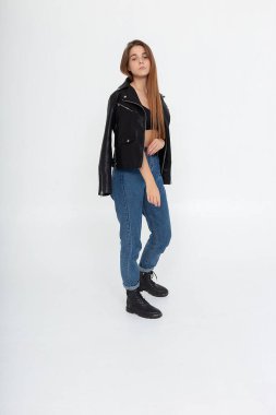 Beyaz arka planda uzun kahverengi saçlı, deri ceketli beyaz bir kadın.