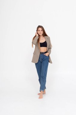 Beyaz arka planda uzun kahverengi saçlı, takım elbiseli beyaz bir kadın.