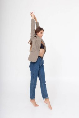 Beyaz arka planda uzun kahverengi saçlı, takım elbiseli beyaz bir kadın.