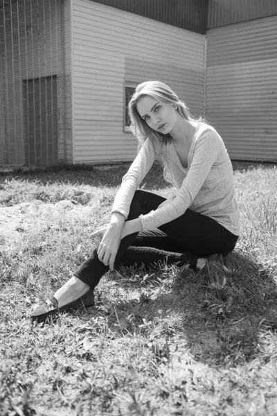 Caucasien jeune maigre jolie fille avec les cheveux longs assis sur la pelouse au mur — Photo