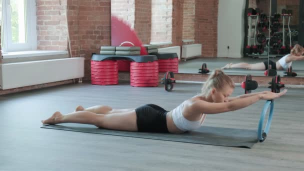 Młody biały sportowe kobieta robi rozciąganie ćwiczenia z pilates pierścień w siłownia — Wideo stockowe