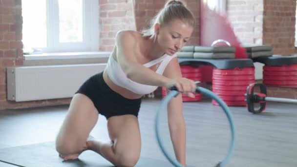 Mladý kavkazský fit sportovní žena dělá prkno cvičení s pilates kroužek v tělocvičně — Stock video