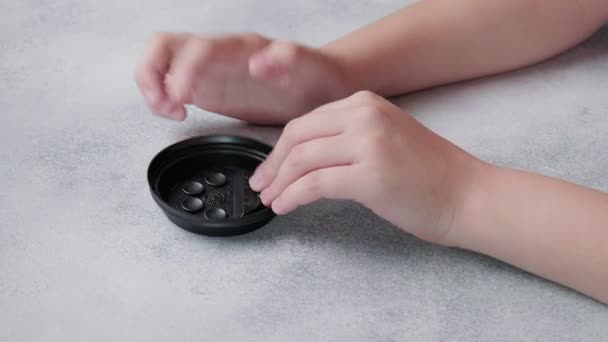 Bambino spinge le bolle poppit sul tappo di plastica nera della tazza di caffè con le dita — Video Stock