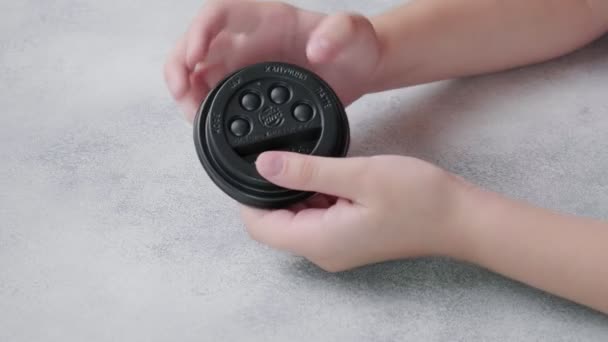 Anak mendorong gelembung poppit pada tutup plastik hitam cangkir kopi dengan jari — Stok Video