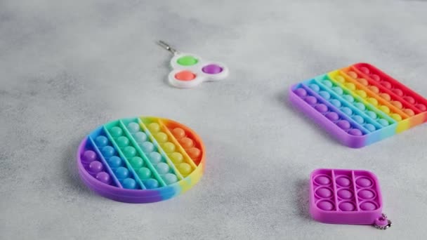 Multicolor regenboog siliconen poppit fidget speelgoed met bubbels, plat op tafel — Stockvideo