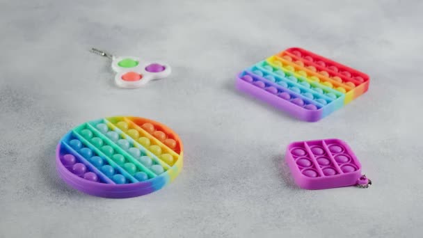 Juguetes multicolor de silicona arco iris poppit fidget con burbujas, plano puesto en la mesa — Vídeo de stock