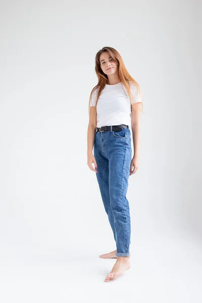 Junges kaukasisches hübsches Mädchen mit langen Haaren im T-Shirt, Blue Jeans im Studio — Stockfoto