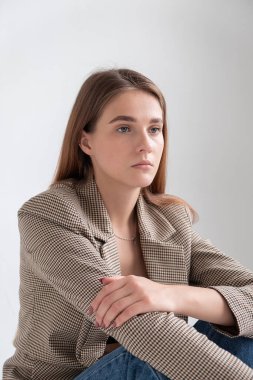 Stüdyoda, uzun kahverengi saçlı, takım elbiseli, beyaz bir kadın vardı.