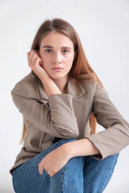 Stüdyoda, uzun kahverengi saçlı, takım elbiseli, beyaz bir kadın vardı.