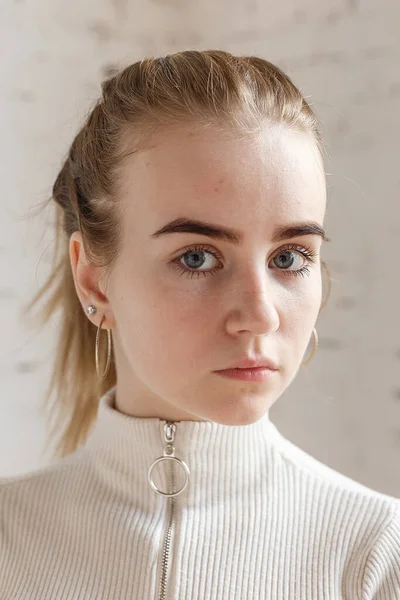 Potret closeup model remaja bijaksana dengan mata biru mengenakan sweater putih — Stok Foto