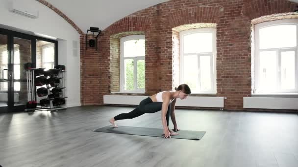Flexibel kaukasiska passform flicka i sportkläder gör yoga, stående i krigare pose — Stockvideo