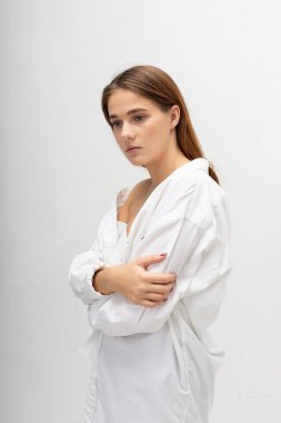 Uzun kahverengi saçlı, mavi kotlu, beyaz bir kadın.