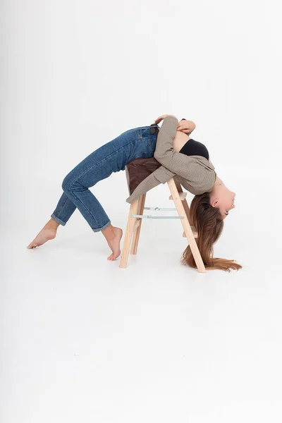 Mager kvinna liggande i broställning på trästege vid ateljé med bara fötter — Stockfoto