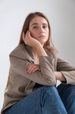 Stüdyoda, uzun kahverengi saçlı, takım elbiseli, beyaz bir kadın vardı.