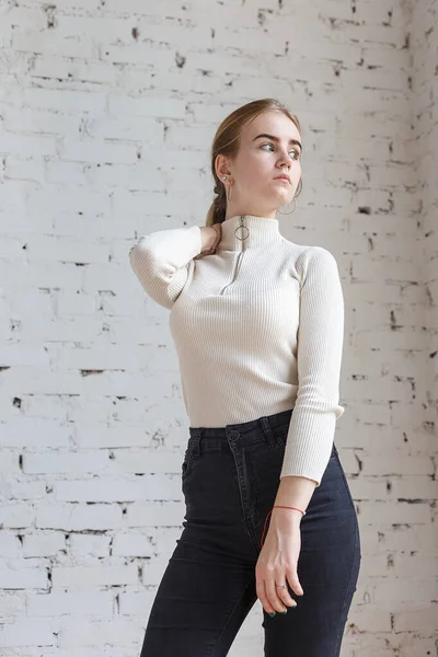 Retrato de jovem modelo adolescente pensativo vestindo suéter branco e jeans pretos — Fotografia de Stock