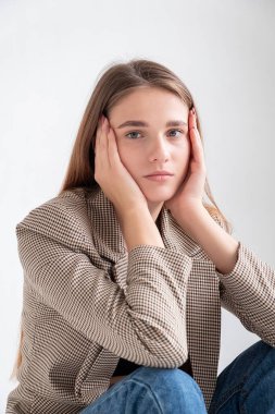 Stüdyoda, uzun kahverengi saçlı, takım elbiseli, beyaz bir kadın vardı.