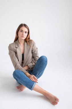 Stüdyoda, uzun kahverengi saçlı, takım elbiseli, beyaz bir kadın vardı.