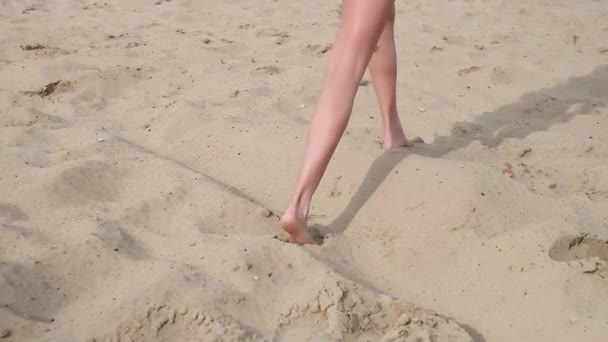Zbliżenie na chude kobiety nogi chodzenie z gołymi stopami na piaszczystej plaży, opalanie — Wideo stockowe