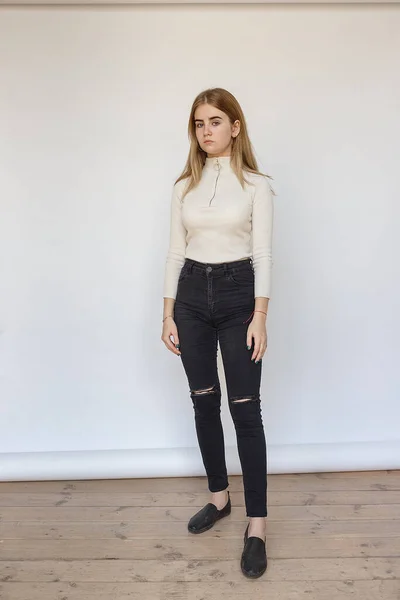 Retrato de jovem modelo adolescente pensativo vestindo suéter branco e jeans pretos — Fotografia de Stock