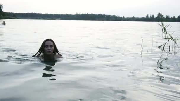 Fit slank nat mooi vrouw in bikini lopen uit het water na het zwemmen in meer — Stockvideo