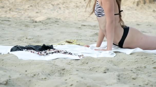 Сексуальна спокуслива молода азіатська жінка в купальнику засмагає, охолоджується на піщаному пляжі — стокове відео