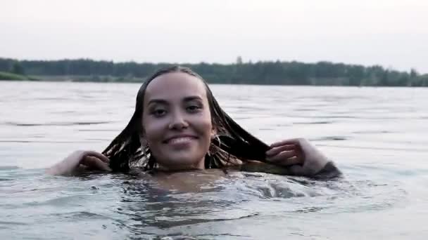 Genç ve çekici Asyalı bir kadının gölette yüzüp eğlenmesine yakın çekim. — Stok video