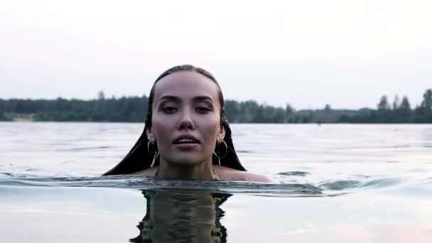 Primer plano en la cara de joven atractiva relajado asiático mujer nadando en estanque o lago — Vídeos de Stock