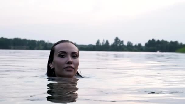 Primer plano en la cara de joven atractiva relajado asiático mujer nadando en estanque o lago — Vídeo de stock