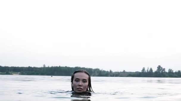 Primer plano en la cara de joven atractiva relajado asiático mujer nadando en estanque o lago — Vídeo de stock