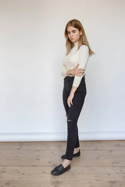 Retrato de jovem modelo adolescente pensativo vestindo suéter branco e jeans pretos — Fotografia de Stock